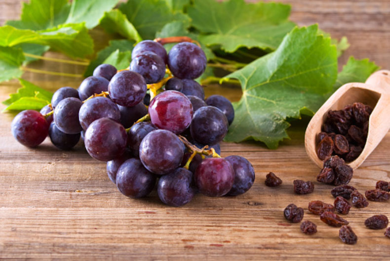 grapes and raisins on a hardwood table